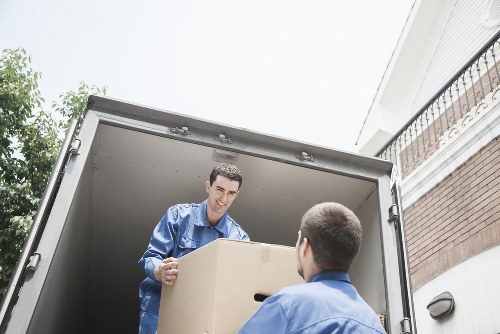 Local movers handling boxes and furniture during a flat move