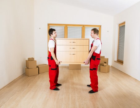 Packed boxes and furniture being loaded into a local removal van